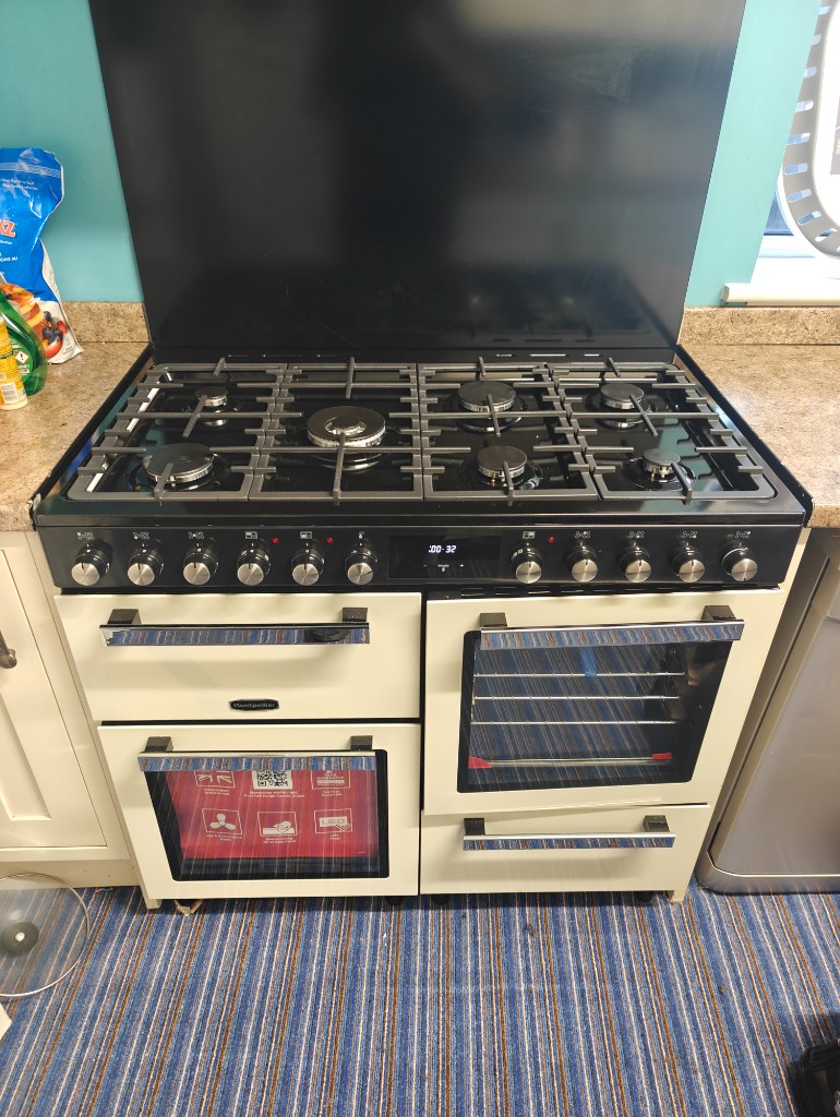 Cream Montpellier range cooker with black splashback in a fitted kitchen